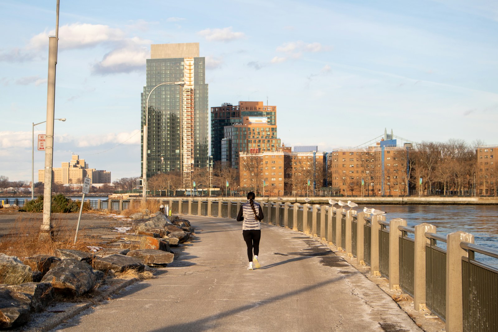Runner on the boulevard by the river in the city